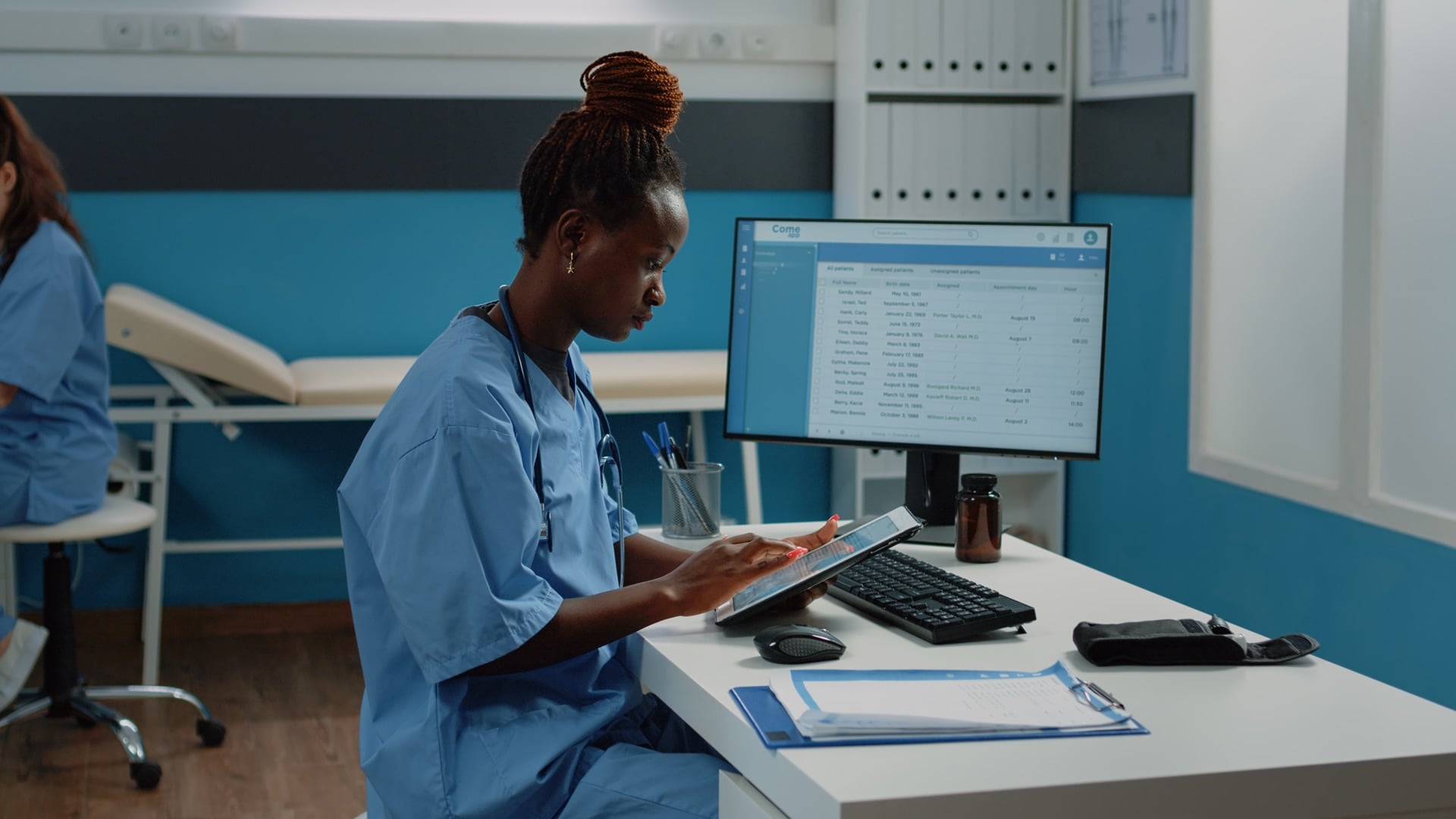 Ugandan healthcare professional reviewing patient data on a digital system at Mulago National Referral Hospital, Kampala